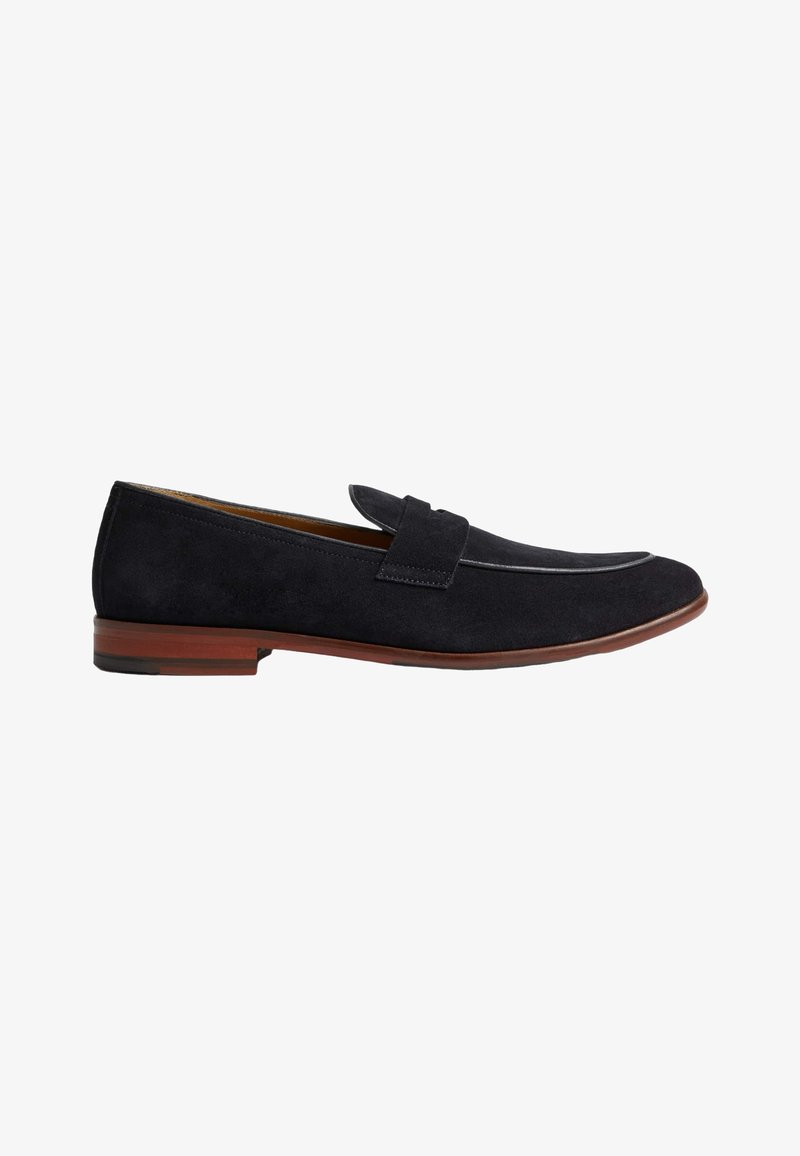 Marineblauwe suede instappers met een vlakke hak, gedetailleerde stiksels en een decoratieve band over de wreef. Leren zool met een lichtbruine accent.