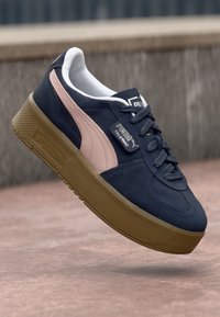 Navy blue suede sneakers with pink accents and a beige rubber sole. Features round toe, lace-up front, and Puma branding on the side.