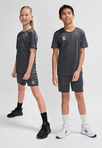 Grau athletic apparel Set für Kinder, bestehend aus T-Shirts mit kurzen Ärmeln und Shorts mit kontrastierenden Akzenten, aus leichtem Material, kombiniert mit Sneakers.