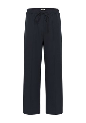 Pantalones de pierna ancha negros con cinturilla elástica y cordón, y detalles de costura frontal, etiquetados "soaked" en la parte trasera de la cintura.