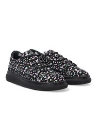 Schwarze Sneakers mit einer gemusterten Oberfläche, die farbenfrohe Icons und Texte zeigt. Runde Zehenpartie und strukturierte schwarze Sohle. Standard-Schnürdesign.
