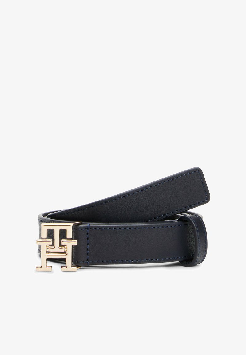 Marineblauwe leren riem met een glanzende afwerking, voorzien van een goudkleurige logo-buckle en contrasterende stiksels langs de randen. Verstelbare lengte.