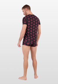 Haut ajusté à manches courtes et short assorti en tissu sombre avec un motif en vagues roses. La matière semble lisse avec une texture légère.