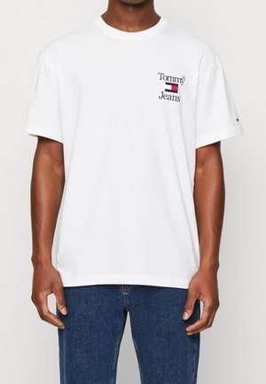 T-shirt en coton blanc avec un logo en noir et rouge "Tommy Jeans" sur la poitrine à gauche. Manches courtes et coupe décontractée.