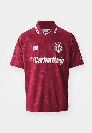 Camiseta de fútbol corta de mangas en color marrón con cuello, que presenta un patrón texturizado, logotipo bordado y acentos en blanco.