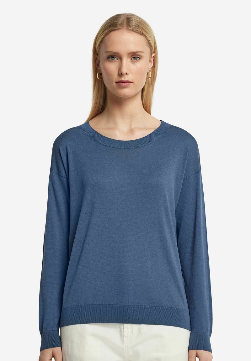 Blå stickad tröja med rund halsringning och långa ärmar, med en mjuk textur och ribbade detaljer vid ärmkanterna och nederkanten.