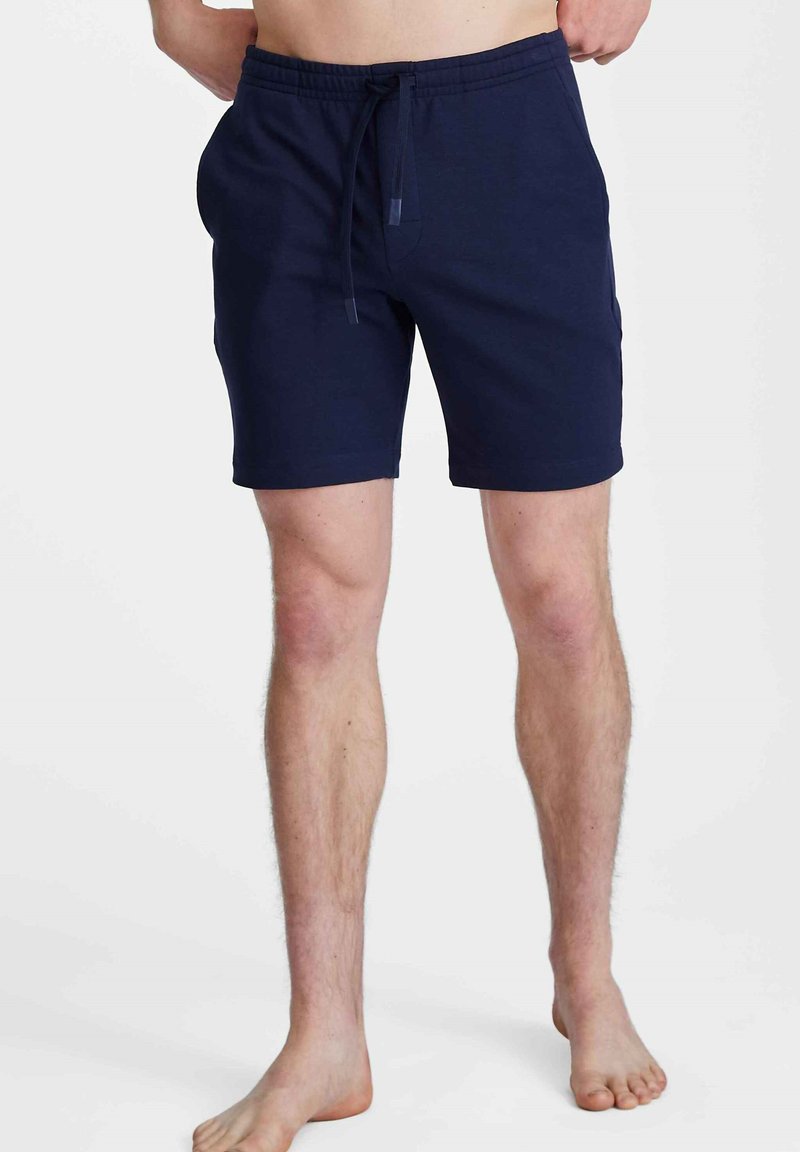 Shorts en coton bleu marine avec une taille élastique et un cordon de serrage. Dotés de poches latérales et d'une coupe décontractée, longueur mi-cuisse.