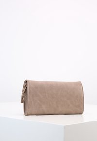 Beige kabelka z umělé kůže s designem na přehnutí, řetízkovým detailem, hladkým povrchem a minimalistickým stylem.
