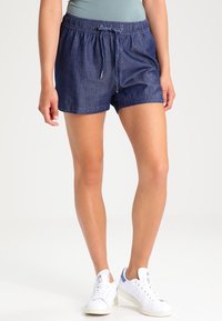 Shorts en denim avec une taille élastique et un cordon de serrage, présentant une coupe décontractée, une longueur au-dessus du genou et une couleur bleue foncée unie.