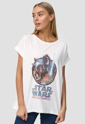 T-shirt en coton blanc avec un imprimé graphique de personnages de Star Wars, avec un cadre rond et du texte bleu indiquant "STAR WARS LE DERNIER COMMANDEMENT."