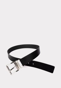 Ceinture en cuir noir avec une boucle en argent brillant, comportant cinq trous de réglage et un motif intérieur texturé. Fini lisse avec des bords droits.