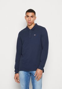 Polo a maniche lunghe blu navy con colletto, patta con due bottoni, piccolo logo sul petto e orlo dritto. Realizzato in un morbido tessuto testurizzato.