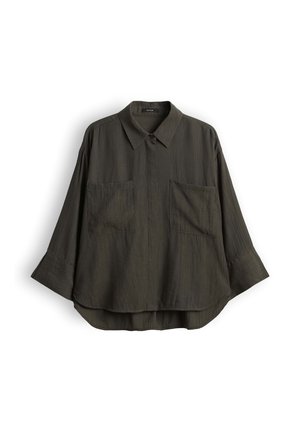 Chemise vert olive foncé à manches longues avec larges poignets, deux poches poitrine avant, un col pointu et un ourlet légèrement incurvé.