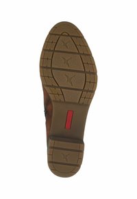 Brown leather shoe with a rubber outsole featuring a patterned tread, a red product label and a rounded heel for support and grip.