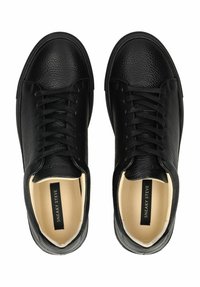 Schwarze Ledersneaker mit strukturierter Oberfläche, ausgestattet mit kontrastierenden Schnürsenkeln, gepolsterter Zunge und einem beigen Innenfutter. Markenetikett im Inneren sichtbar.