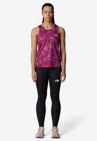 Purple tie-dye athletic tank top paired with black leggings. Features logo accents and a lightweight, breathable material. Athletic shoes included.