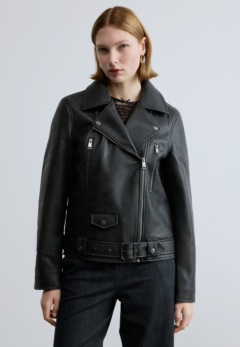 Schwarze Leder-Motorradjacke mit weitem Kragen, Reißverschlusstaschen und einem taillierten Gürtel. Verfügt über eine strukturierte Oberfläche und metallische Hardware-Akzente.