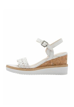 Biała sandałka na koturnie z paskiem o plecionym wzorze i korkowym koturnem o fakturowanej powierzchni. Regulowane zapięcie na klamrę.