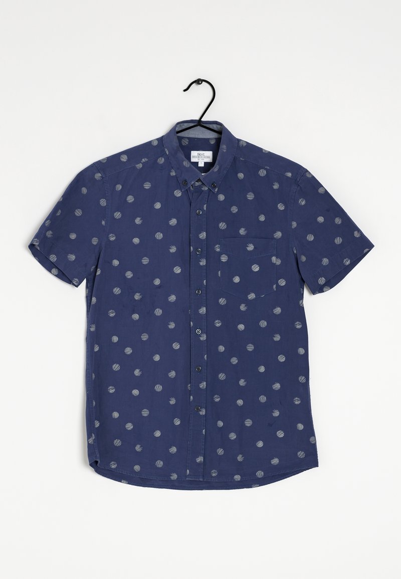 Chemise à manches courtes en tissu bleu marine avec des motifs circulaires gris, col boutonné et poche à gauche sur la poitrine. Texture lisse, design décontracté.