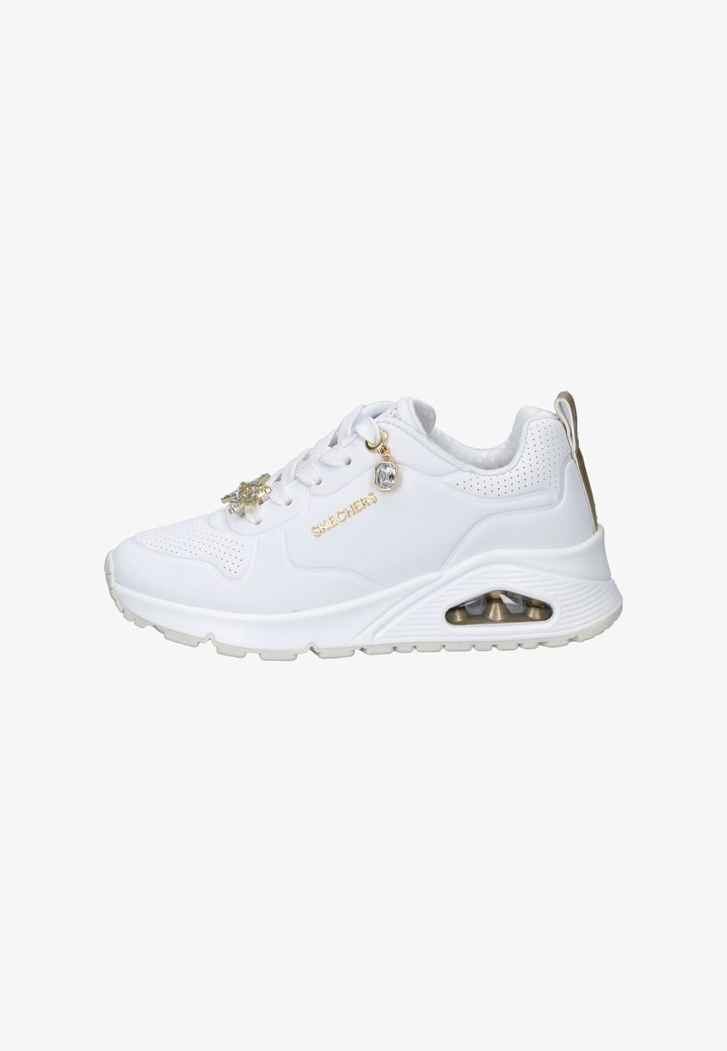Witte Skechers sneaker met dikke zool, transparante luchtkussen, gouden logo en decoratieve juweelaccenten op de veters, zijkant en hieltab.