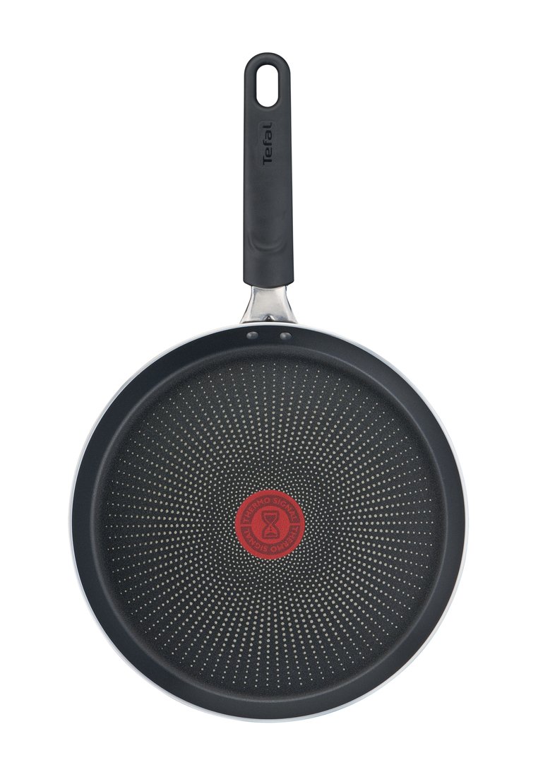 Patelnia z nieprzywierającą powłoką o czarnym, teksturowanym wnętrzu, srebrnej krawędzi i czarnej plastikowej rączce z pętlą do zawieszania. Czerwony wskaźnik Thermo na środku.