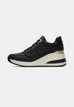 Czarny sneaker z białą podeszwą platformową, złotymi oczkami i metalicznym złotym akcentem na pięcie, przedstawiony w profilu bocznym na gładkim tle.