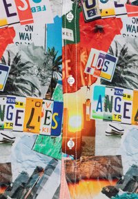 Chemise à manches courtes présentant un collage coloré de plaques d'immatriculation de Californie et d'images tropicales, avec un design à boutons et un tissu texturé.