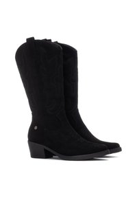 Botas de vaquero de ante negro con un caña alta, costura decorativa, línea superior curva y tacón cuadrado. Presentan un acento de logo metálico.