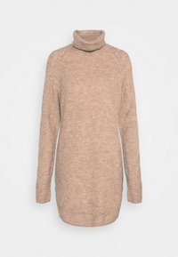 Pull en maille côtelée, couleur marron clair, avec col roulé. Il présente de longues manches et une coupe décontractée avec un dos légèrement allongé.