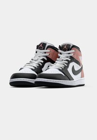 Pair of black, white, and pink high-top Nike Air Jordan sneakers with white laces on a white background.
