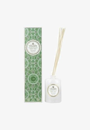 Hvid glasdiffuser med rør, pakket i en grøn dekorativ kasse med intrikate mønstre. Etiketten siger "VOLUSPA Moroccan Mint Tea."