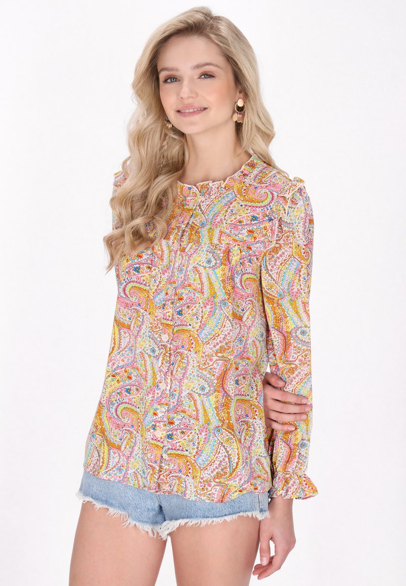Blusa in tessuto leggero con motivo paisley colorato, caratterizzata da un collo rotondo, chiusura con bottoni e dettagli a volant sulle maniche.