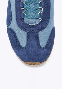 Sneaker blu con una combinazione di materiali in suede e tela, lacci rotondi, superficie testurizzata e suola in gomma con un motivo.