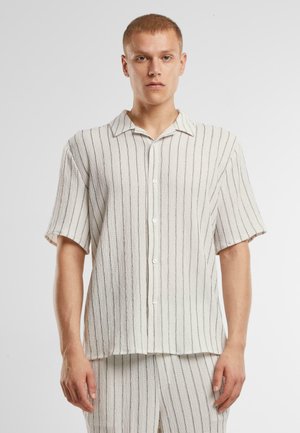 Camicia a maniche corte con righe verticali in crema e grigio, con fronte con bottoni e vestibilità rilassata. Tessuto testurizzato.