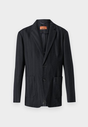 Blazer noir à motif chevrons avec deux poches avant, revers crantés et deux boutons. Texture lisse avec une coupe ajustée.