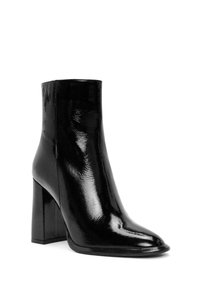 Bottines en cuir verni noir avec un bout pointu, un large talon bloc et une surface lisse et brillante. Design simple, sans accents visibles.