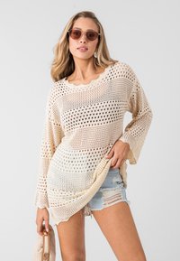 Lichtbeige opengewerkt sweater met wijdvallende mouwen en geribbelde halslijn. Draag je over versleten denim shorts, met een losse, relaxte pasvorm.