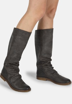Botas de cuero marrón hasta la rodilla con un diseño caído, suelas planas y un acabado texturizado. La parte superior presenta una apertura amplia.