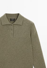 Olivgrön långärmad polotröja med tre knappar och klassisk krage, tillverkad av 100% kashmirmaterial.