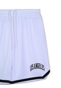 Shorts bianchi in rete con vita regolabile e rifiniture nere. "LOS ANGELES" è stampato in grassetto nero sull'orlo.