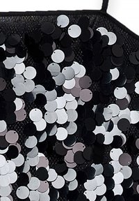 Zwarte stof bedekt met cirkels van pailletten in verschillende tinten zwart, grijs en wit, wat een schitterend textuurpatroon creëert.