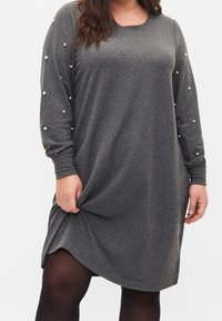 Graues gestricktes Kleid mit langen Ärmeln, mit Perlenakzenten an den Ärmeln, einem runden Halsausschnitt und einem leicht geschwungenen Saum.