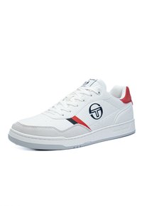 Sneaker sportive bianche con tomaia in pelle liscia, dettagli rossi, striscia nera e logo; dotati di una suola in gomma testurizzata.