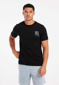 Schwarz kurzärmliges T-Shirt aus Baumwolle mit einem kleinen Grafikdruck auf der linken Brust und einem klassischen Rundhalsschnitt.