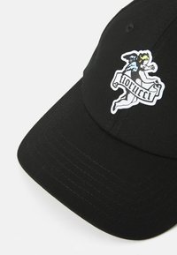 Cască de baseball neagră din bumbac, cu un grafic colorat al unui înger și textul "florucci" pe partea din față. Material texturat cu detalii cusute.