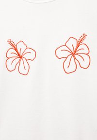 Bela majica s kratkimi rokavi, ki prikazuje dva vezena rdeča hibiskusa. Cvetovi so obrobljeni v rdeči barvi z finimi črtami in imajo podrobne akcentne dele prašnikov.