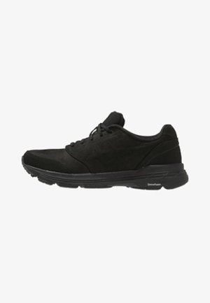 Scarpa da ginnastica nera con lacci frontali, collo imbottito e suola ammortizzata progettata per comfort e supporto nell'uso quotidiano.