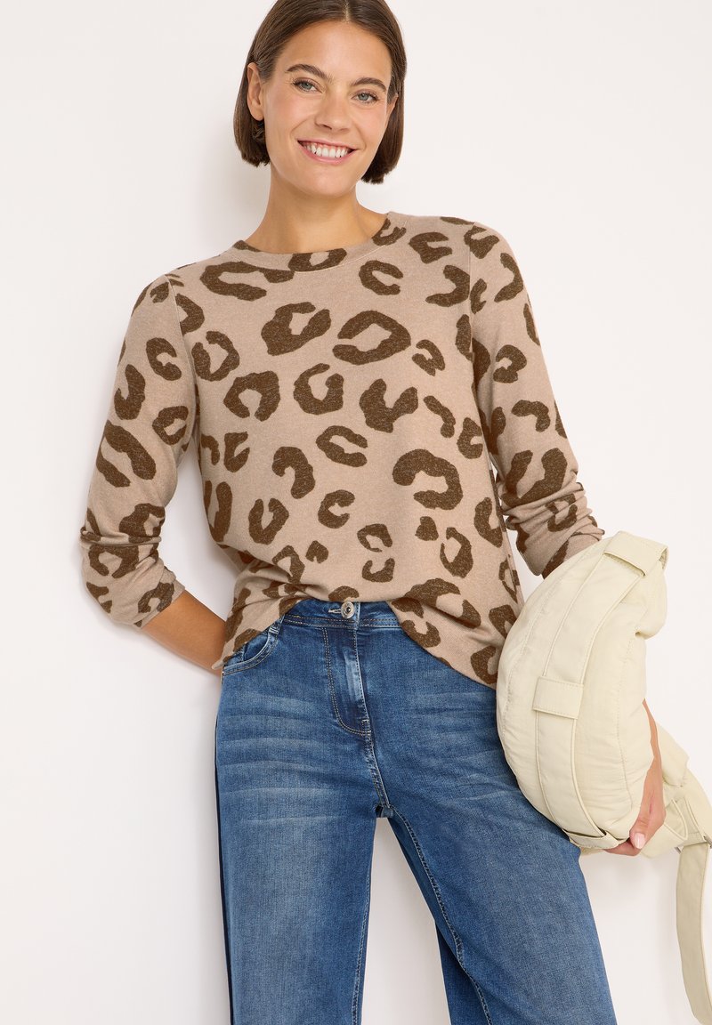 Maglione a stampa leopardata in tonalità beige e marrone, con scollatura rotonda e maniche lunghe, abbinato a jeans in denim blu e una borsa beige.