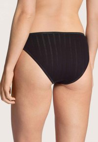 Zwarte katoenen bikini slipjes met verticale ribbelstructuur, hoge taille en elastische tailleband. Geen zichtbare bevestigingen of accenten.