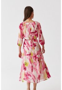 Kwiatowa sukienka midi z lekkiego, przezroczystego materiału w różowe, żółte i zielone wzory pędzlem. Długie rękawy i detal w postaci zawiązanego pasa.